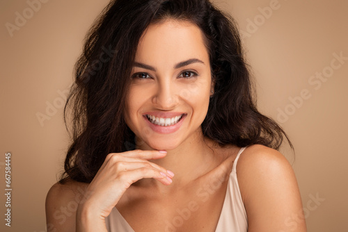 Closeup portrait of pretty brunette woman smiling at camera