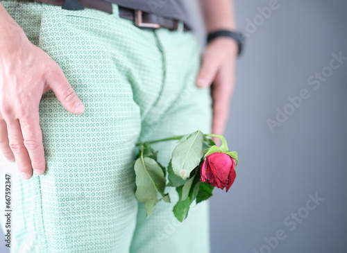 Withered flower between the man legs. Weak erection during sex in man concept