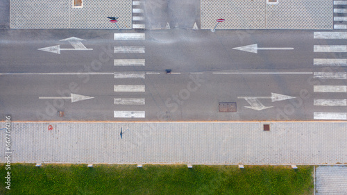 Aerial zenithal view of an empty road with road signs on the ground.