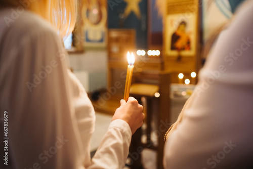 Orthodox church candle background. Hand holding candle during ceremony. Baptism ceremony in East of Europe.