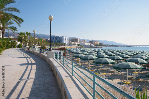 Beach promenade in Manfredonia, blue sky, umbrellas and loungers on the beach, Apulia region in southern Italy