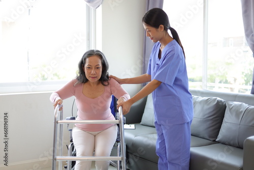 Female doctor help a senior patient who is doing physical therapy and is practicing walking with a walking stick.