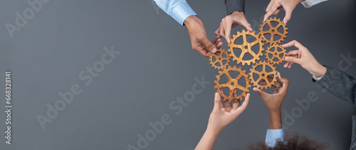 Panoramic shot top view of business people holding cog wheel as unity and teamwork in corporate workplace concept. Office worker colleague with symbol of visionary system for business success. Concord