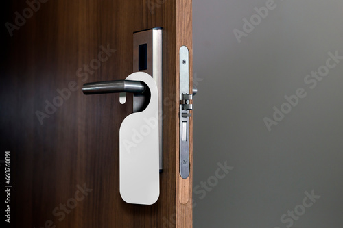 wooden door with empty tag hanging on the handle. Ideal template for mockup do not disturb sign.