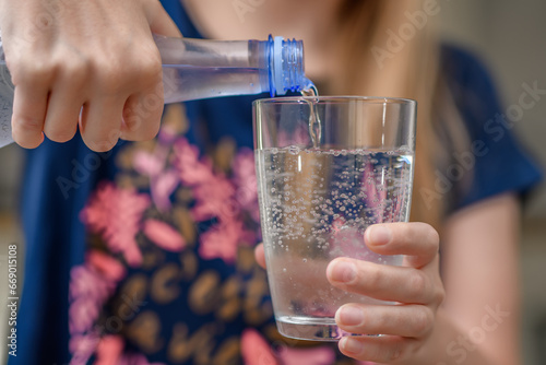 Woda w butelce plastikowej nalewana do szklanki