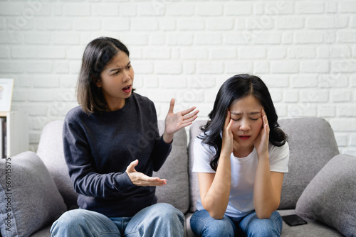 Asian lesbian couple arguing on the sofa