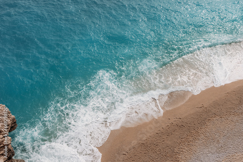 Turkish Sea, top view. Kaputas Beach in Turkey. Beautiful waves roll over the sandy beach. Blue sea and yellow sand. Beach near the town of Cash in Turkey. Copy space