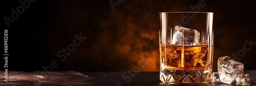 A glass of whiskey with ice cubes on a dark backdrop. Classic luxury drink. Suitable for beverage advertisements, promotions, backdrop, banner with free space for text