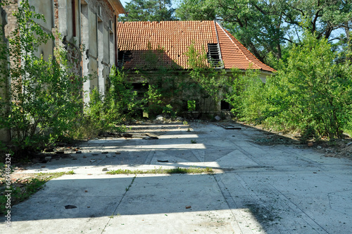 Zarośnięty dziko rosnącymi roślinami fragment zrujnowanego budynku kasyna wojskowego w Bornem - Sulinowie. Polska. 