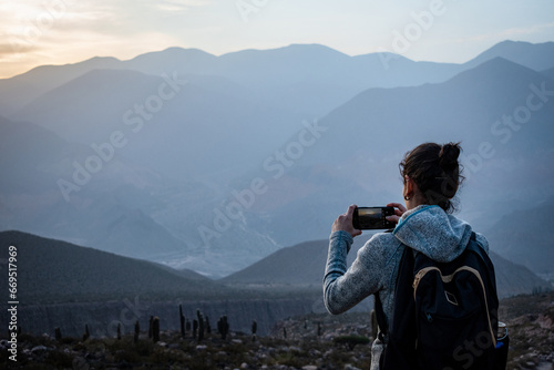 Mujer turista tomando una foto en los cerros de Tilcara, Jujuy, Argentina