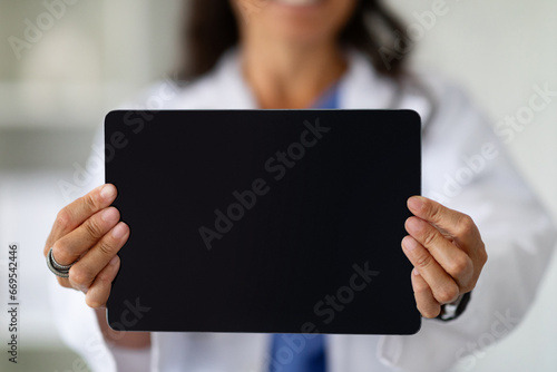 Cropped of lady doctor showing digital tablet with black screen