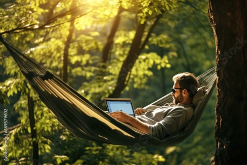 portrait of a European man lying in a hammock with a laptop in nature. remote work