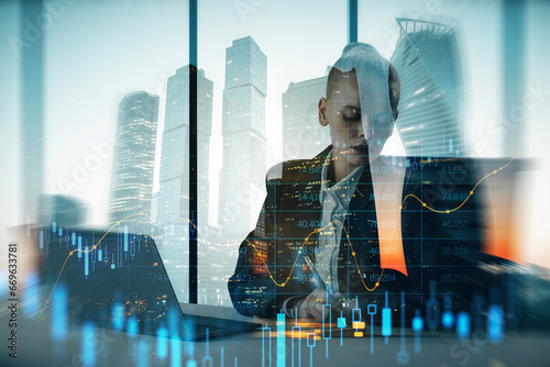 Attractive young european businesswoman silhouette sitting at desk with laptop on blurry city background with forex chart. Success, finance, workplace, ceo and future concept. Double exposure.