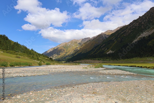 Turgenaksu valley with a river wading on a second stage of Ak-Suu Traverse trek in Karakol, Kyrgyzstan