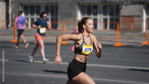 Female jogger run marathon. Thin girl work out. Woman runner jog long distance. Finish line road. Sportswoman overtake man. Sporty athlete train. Fast sprint champion. Fit sport body. Active city life