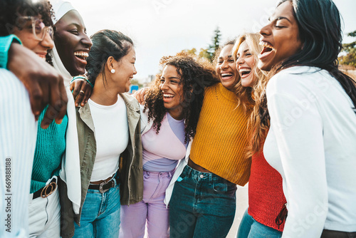 Multi ethnic group of young women hugging outside - Happy girlsfriends having fun laughing out loud on city street - Female community concept with cheerful girls standing together - Women power