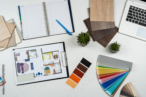 Architect's table with laptop, house plab blueprint and color wwoden sampler, other work tools