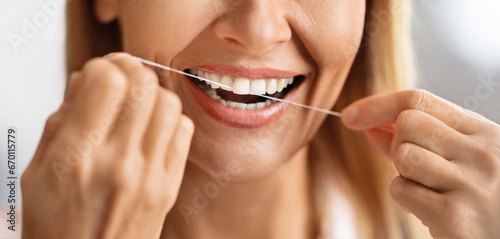 Oral Care. Closeup Shot Of Smiling Mature Female Using Dental Floss