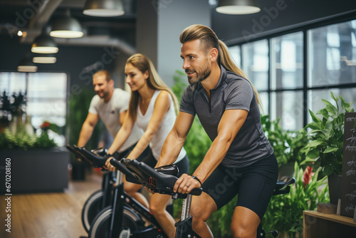 A man and a woman riding bikes in a gym.