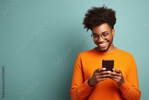 wall studio blue isolated aside focused jumper orange dressed connection internet good enjoys device phone cell modern sms types woman american african delighted cheerful photo background