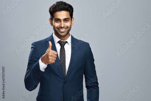 Professional man in suit showing approval with thumbs up gesture. Suitable for business and success concepts.