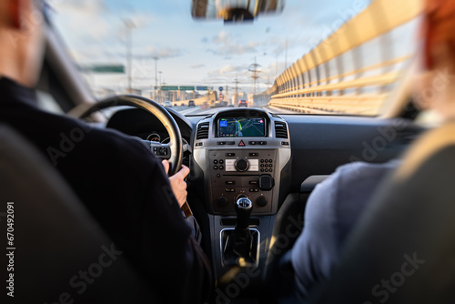 Motion zoom Motorway. Ring bypass road. Blurry view of the road through the windshield of the car. The car control panel, the navigator is turned on. The driver and passenger are looking at the road