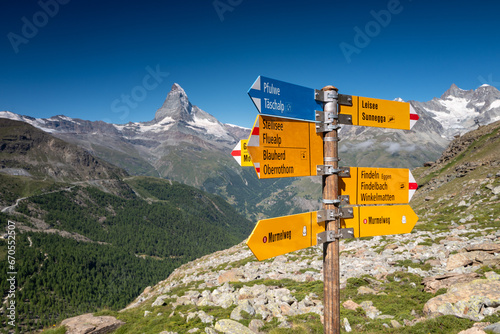 Switzerland Travel - typical trail Signpost in the Swiss Alps in the Zermatt region with view of the Matterhorn in the background.