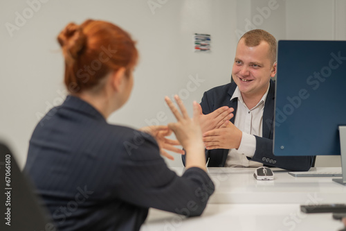 Business partners communicate in sign language. A deaf boss gives a task to a subordinate woman.