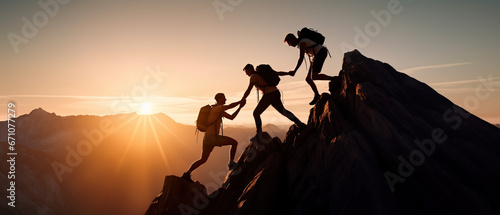 Three climbing friends helping each other as a team reach the mountain peak