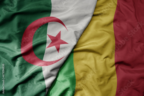 big waving national colorful flag of algeria and national flag of mali .