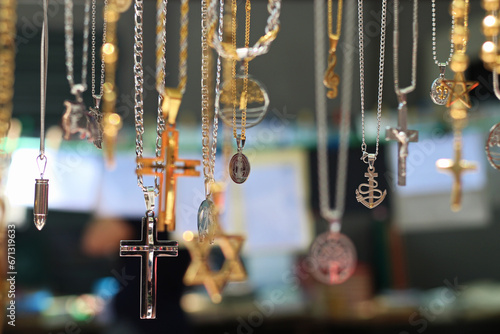 varias correntes com símbolos em pingentes em forma de cruz, estrela de david, santos, projéteis, a venda na feira de rua.