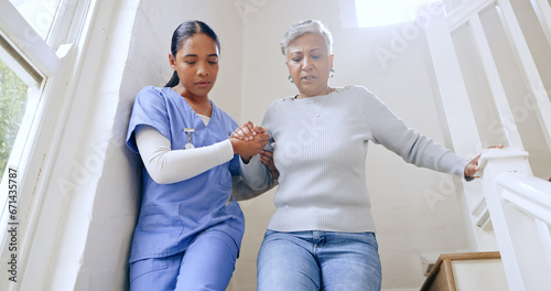 Woman, nurse and helping senior on stairs in retirement home for support, trust or healthcare. Female person, medical caregiver holding hands with retired or mature patient down a staircase at house