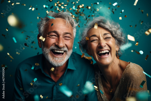 Happy laughing senior couple women and man with glasses and falling confetti on teal blue background. Modern old guy with smile celebrating at party. Winning Lottery. Generative AI.