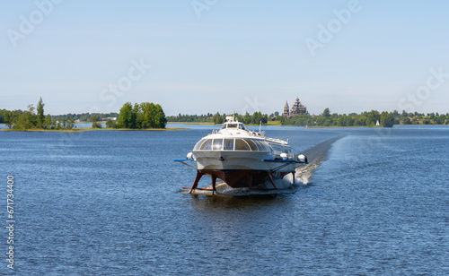 Tourist motor ship Meteor hydrofoils floating on Lake Onega against the background of the Kizhi Historical Park