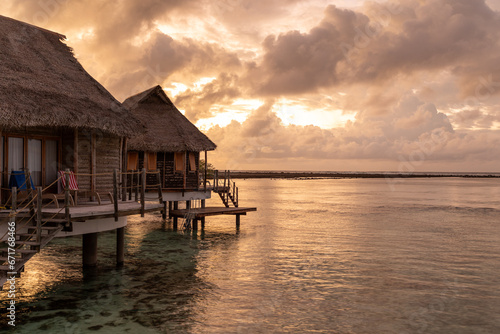 French Polynesia Tikehau atoll. Beautiful sunrise over the coral reef lagoon seen from overwater bungalows.