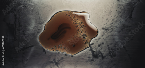 illustrazione di superficie metallica con chiazza di sostanza oleosa, vista da sopra