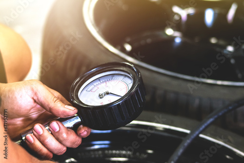 Mechanic using a pressure gauge to measure the pressure of the car.