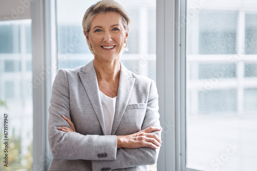 Business woman, portrait or arms crossed by window in corporate financial, investment company or insurance office. Smile, happy or confident mature ceo in about us with success mindset for management