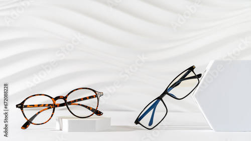 Two pairs of plastic eyeglass frames on white background. Minimalism, eyewear fashion concept. Trendy eyeglasses still life in minimal style. Optic store discount, sale, promotion. Copy space for text