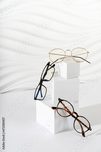 Trendy eyeglasses in plastic and metallic frame on a white background. Close up. Sunglasses and spectacles sale concept. Optic shop promotion banner. Eyewear fashion. Minimalism. Vertical