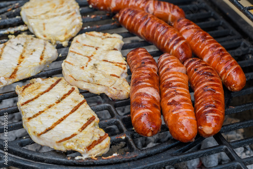 Mięso pieczone na grillu, schab i kiełbasa leżą na ruszcie