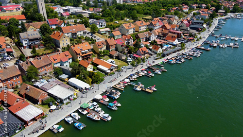 Panoramic aerial photo from drone to Mikolajki townscape - capital of Masurian region on the shore of the holiday resort beautiful summer afternoon. Mikolajki, Mikołajki, Poland, Europe.