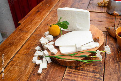 Toma superior de un queso blanco mexicano fresco en una tabla de madera en cubos y rebanadas ideal para lácteos