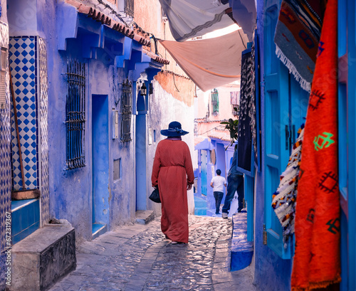 woman walking on the blue streets of Chefchaouen Morocco