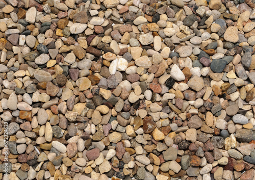 Background of large amount of little dark, brown, red and yellow stones view from above