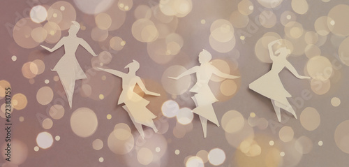 illustrazione con figure femminili danzanti realizzate con ritagli di carta, sfondo con luci e aloni luminosi