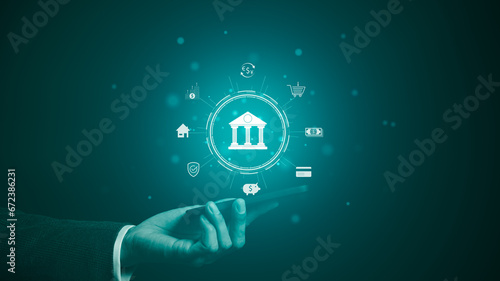 The concept of using digital technology for online banking. Businessman is holding a phone with icons of online banking technology. Customer withdraw money, Internet, bank account, shopping, payment,