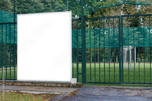 Large square billboard on green soccer field fence. Mock-up.