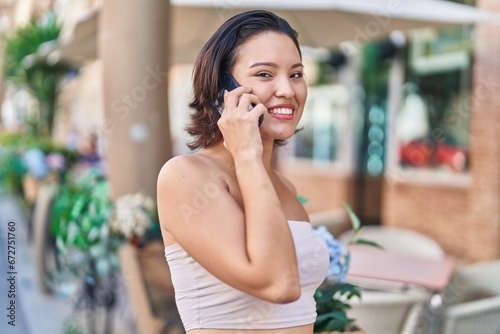 Young hispanic woman smiling confident talking on the smartphone at coffee shop terrace