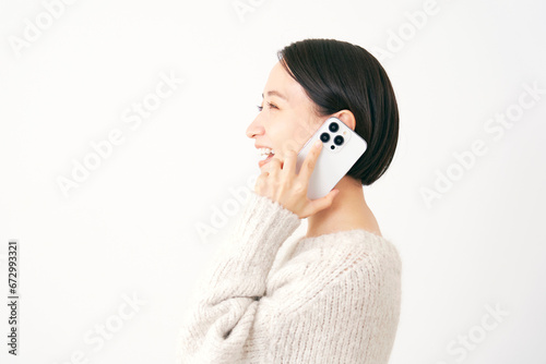 スマートフォンで電話する女性 白背景